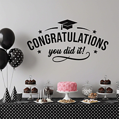Congratulations You Did It graduation wall decal applied to a gray wall above a graduation party dessert table with balloons and cake