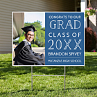 Custom graduation yard sign with photo featuring graduate in cap and gown, blue design with class year and name displayed in front yard