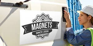 A woman wearing a hard hat opening a truck door with a magnetic sign on the door. 