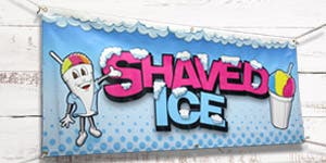 A vinyl banner promoting shaved ice hung on a wood paneled wall.