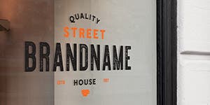 A window sign applied to a coffee storefront window that reads Quality Street Brandname house.